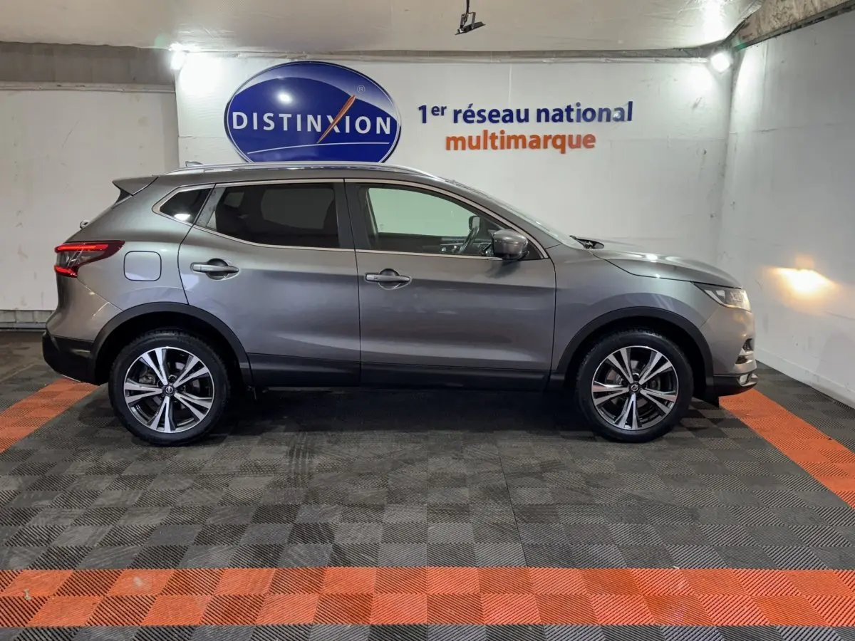Profil droit d'un Nissan Qashqai gris foncé 2019, avec jantes alliage et feux arrière LED distinctifs.