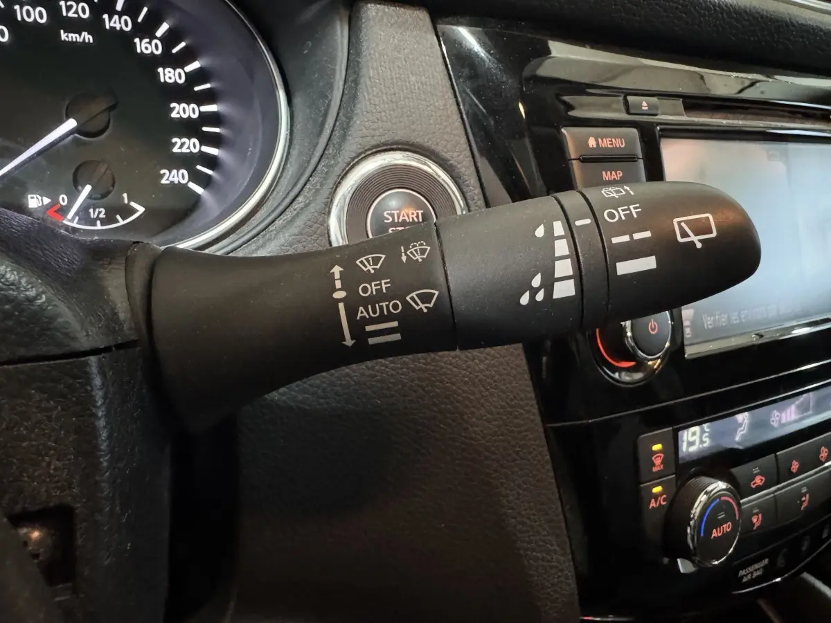 Gros plan sur la commande d’essuie-glace noire du Nissan Qashqai gris foncé, avec tableau de bord et bouton start visibles.