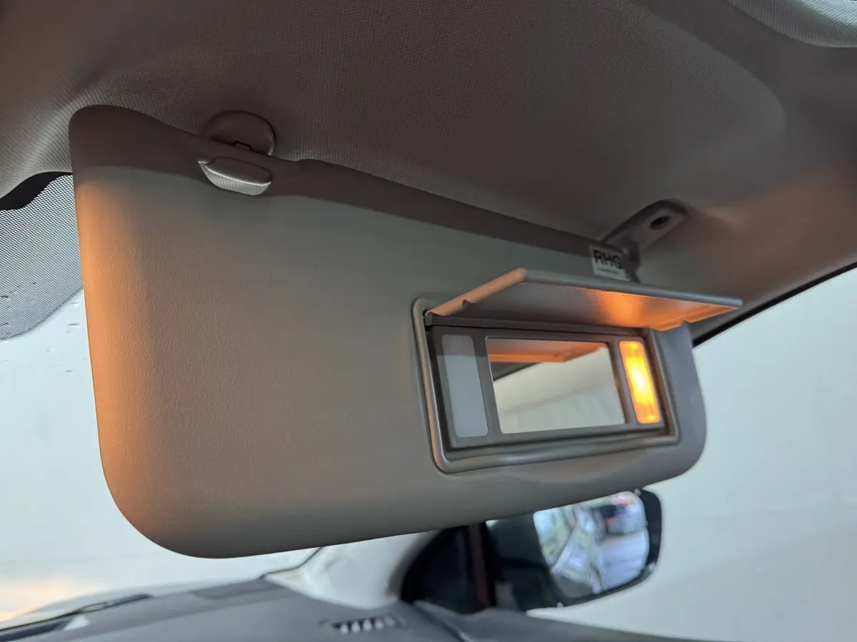 Détail du pare-soleil côté conducteur avec miroir éclairé dans un Nissan Qashqai gris foncé 2019.