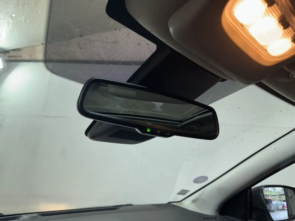 Vue intérieure du rétroviseur central du Nissan Qashqai 2019 avec éclairage intérieur allumé et pare-brise partiellement visible.