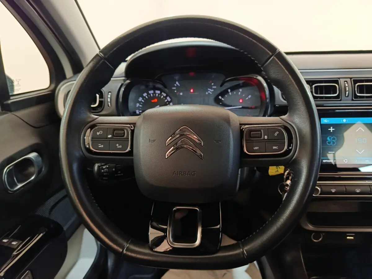 Vue centrée sur le volant cuir noir de la Citroën C3 2021 avec commandes intégrées et tableau de bord numérique.