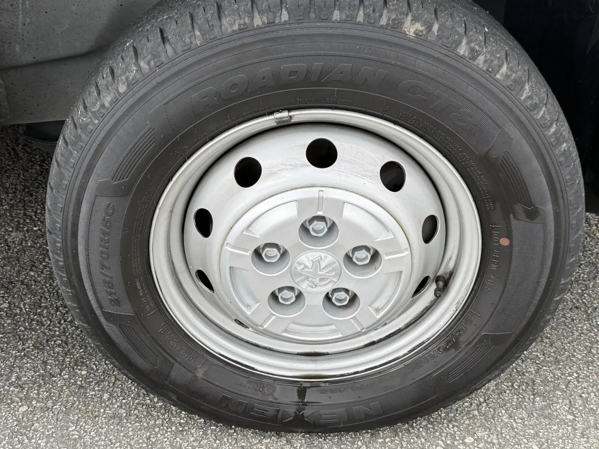 Gros plan sur la roue avant gauche du Peugeot Boxer Fourgon blanc, mettant en valeur la jante acier et le pneu Nexen Roadian.
