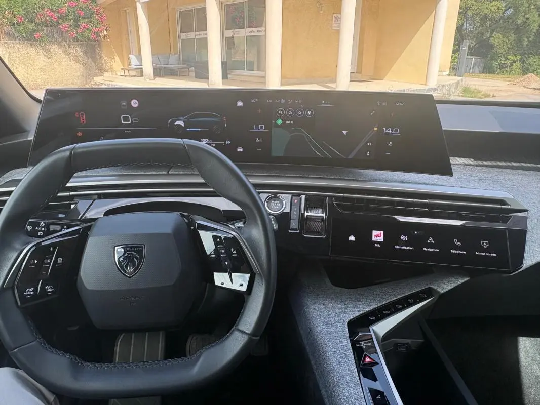 Vue intérieure du tableau de bord du Peugeot 3008 Hybrid 136 e-DCS6 Allure 2025, avec volant compact et double écran numérique.