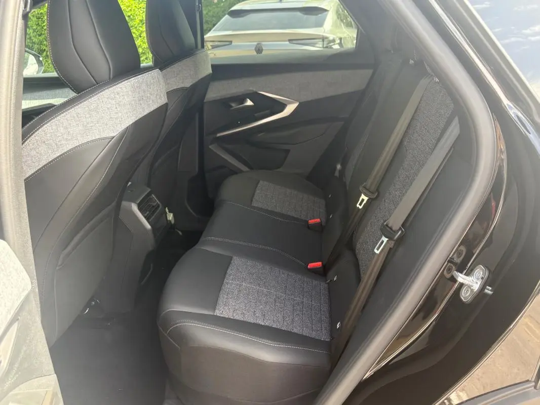 Vue intérieure côté droit des sièges arrière en tissu et cuir gris et noir du Peugeot 3008 Hybrid 136 e-DCS6 Allure 2025 noir.