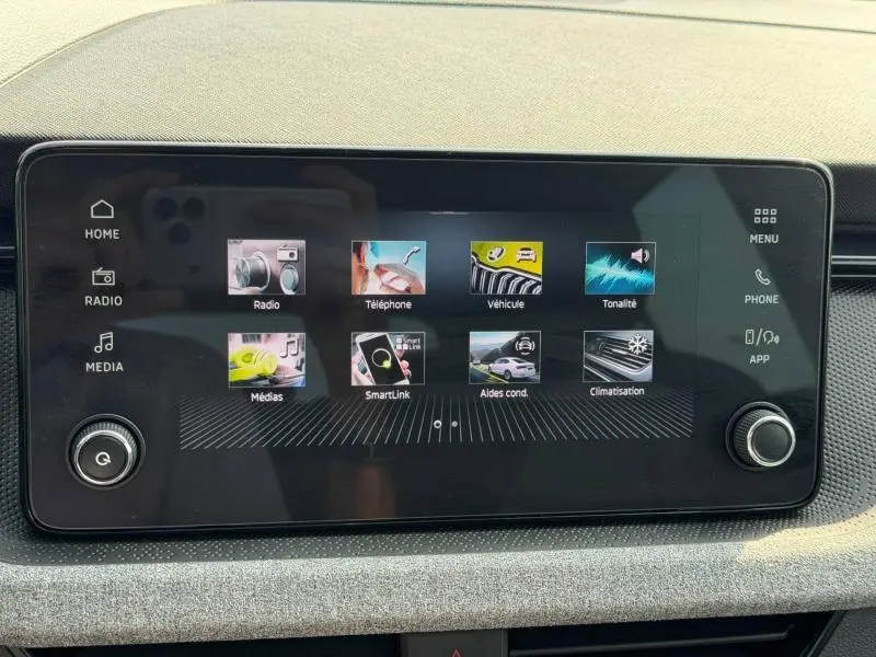 Écran tactile central du tableau de bord de la Skoda Scala 2025, affichant les menus radio, téléphone et climatisation.