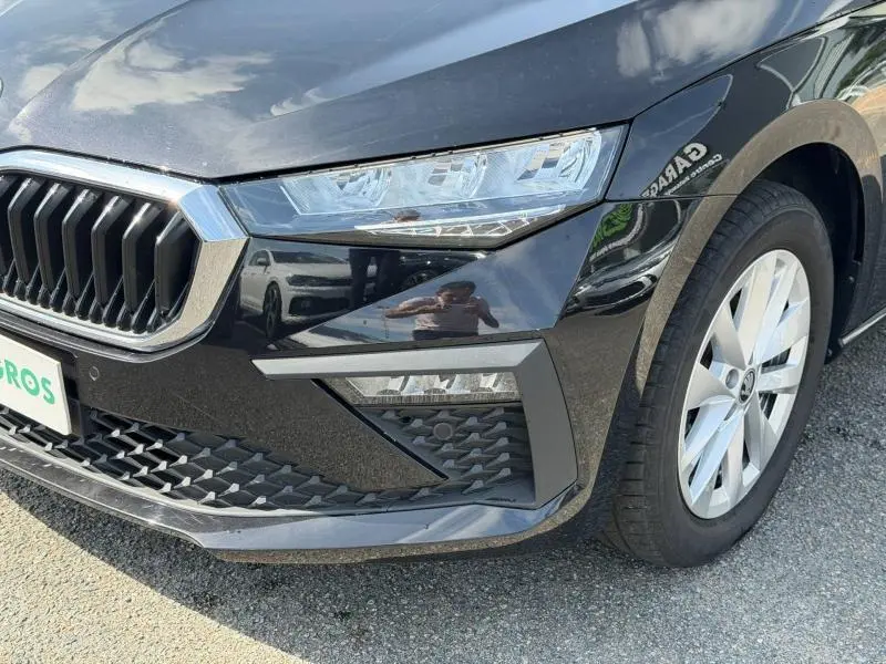 Gros plan sur l'avant droit d'une Skoda Scala noire Magic nacré, mettant en valeur la calandre chromée et les phares LED.