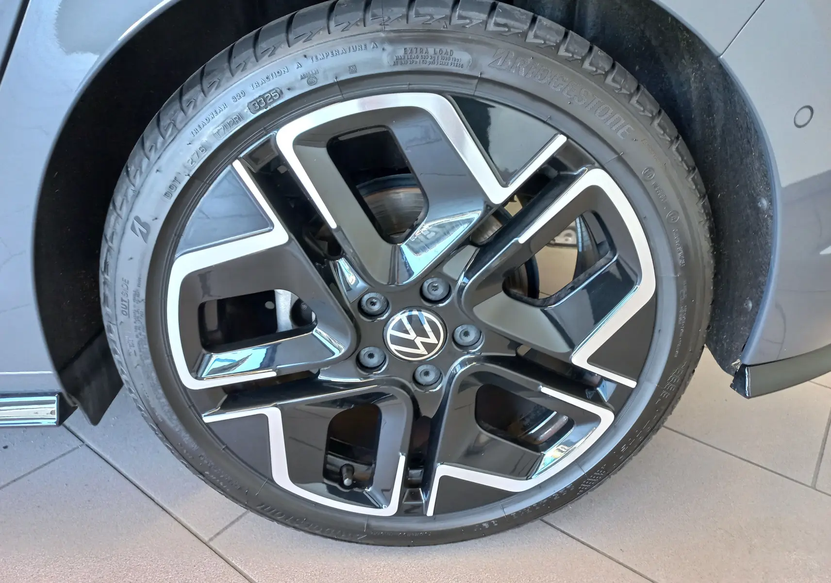 Gros plan sur la jante noire et argentée d'une Volkswagen Golf 1.5 eTSI 150 R-Line Edition gris dauphin.