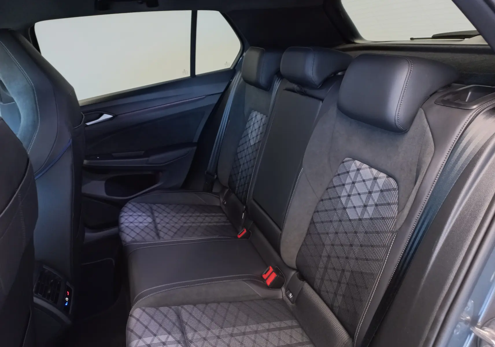 Vue intérieure côté droit des sièges arrière en tissu et cuir gris avec motifs géométriques dans une Volkswagen Golf 1.5 eTSI R-Line 2025.