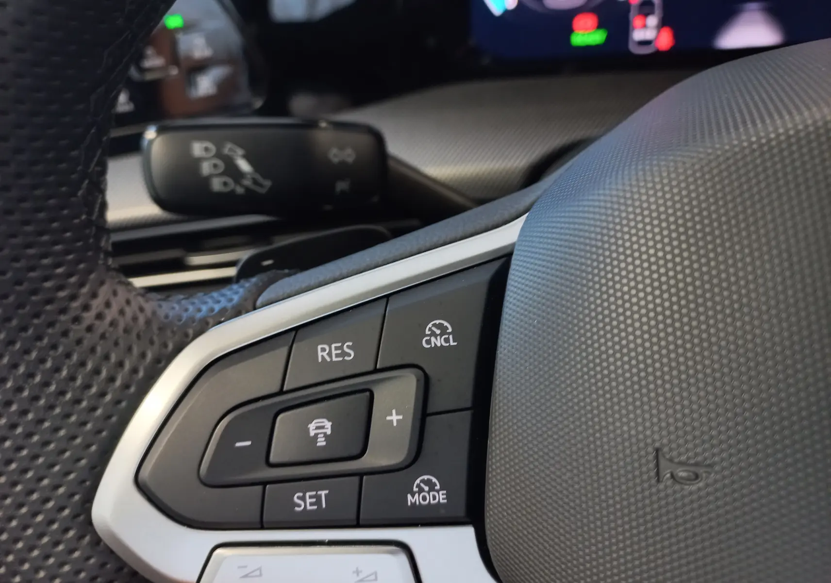 Gros plan sur les commandes du régulateur de vitesse au volant d'une Volkswagen Golf 2025, finition R-Line.