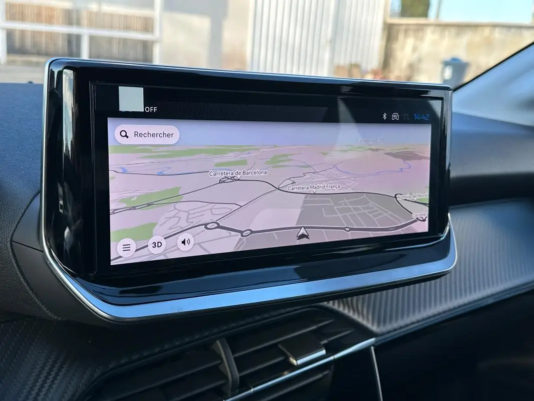 Écran tactile du système de navigation de la Peugeot 208 Hybrid blanc, vue rapprochée de la console centrale.