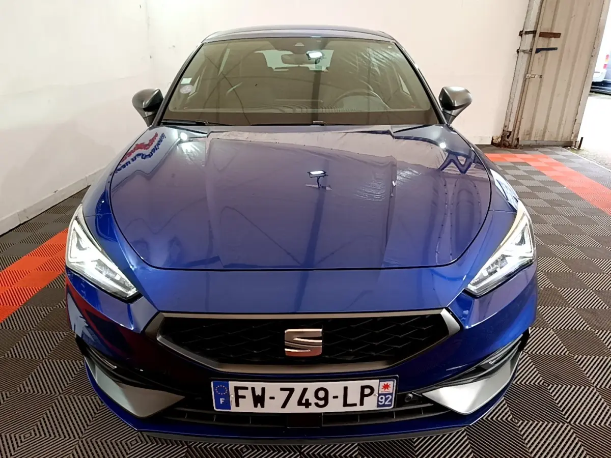 Vue avant d'une SEAT Leon 1.5 eTSI 150 DSG FR bleu, avec calandre noire et phares LED allumés.