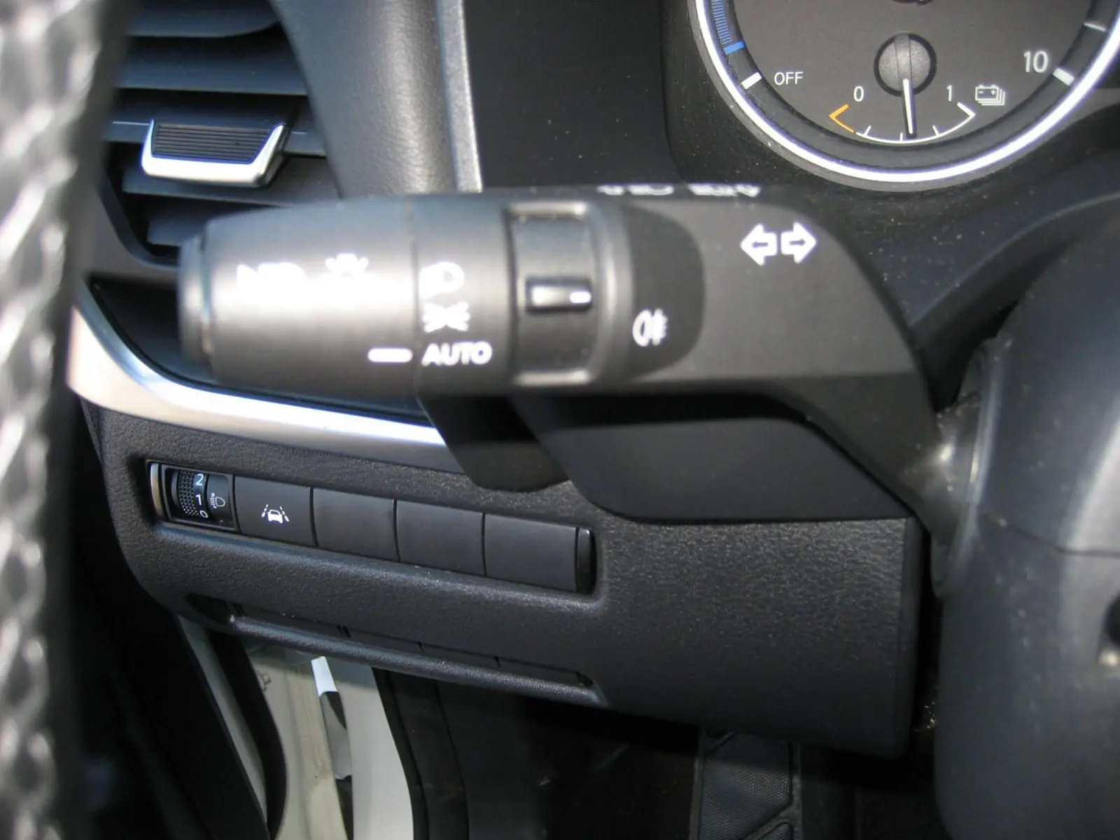 Gros plan sur la commande de clignotants et les boutons de réglage d'assistance au conducteur du Nissan Qashqai blanc nacré 2024.