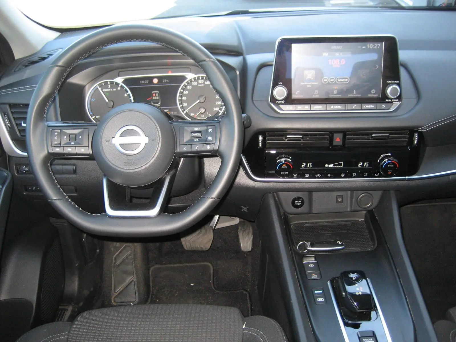 Vue intérieure avant du tableau de bord et volant d'une Nissan Qashqai 2024, avec écran tactile et commandes modernes.
