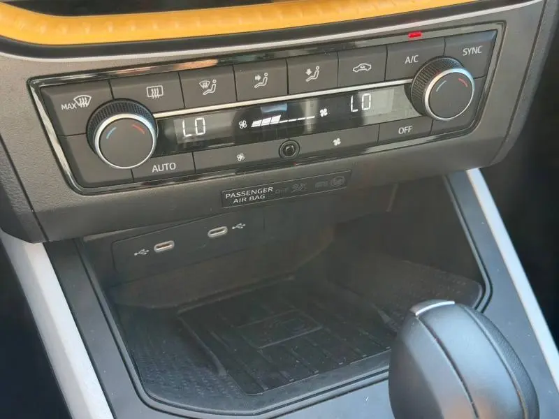 Gros plan sur la console centrale du SEAT Arona 2025 avec commandes climatisation digitale et prises USB visibles.