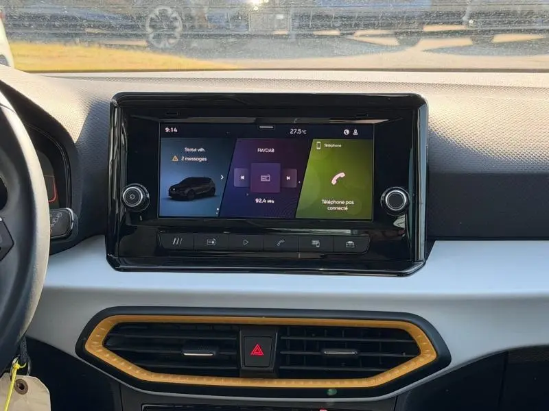 Vue centrale de l’écran tactile du tableau de bord du SEAT Arona 2025 avec cadre noir et aérateurs jaunes.