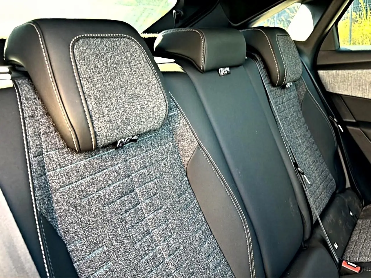 Vue rapprochée des sièges arrière en tissu gris et cuir noir du Peugeot 3008 2025, version hybride allure.
