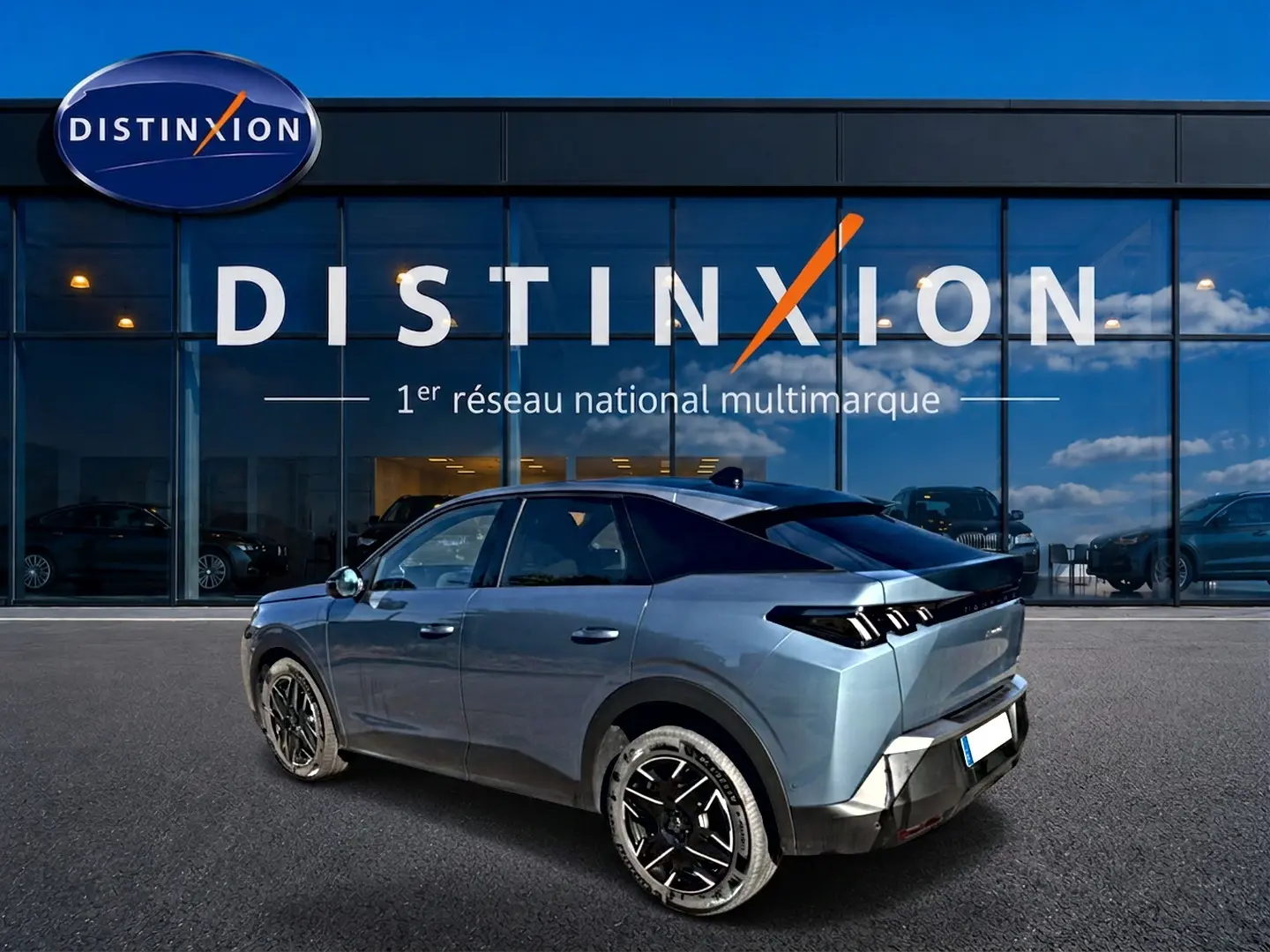 Peugeot 3008 bleu en 3/4 arrière droit, avec jantes alu noires et toit noir devant une vitrine Distinxion.