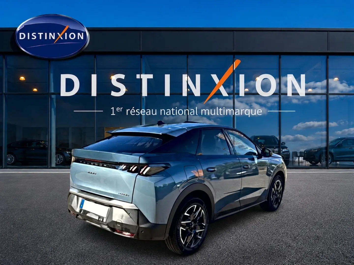 Peugeot 3008 bleu 3/4 arrière droit, avec jantes alu et feux arrière à LED, devant un showroom Distinxion.