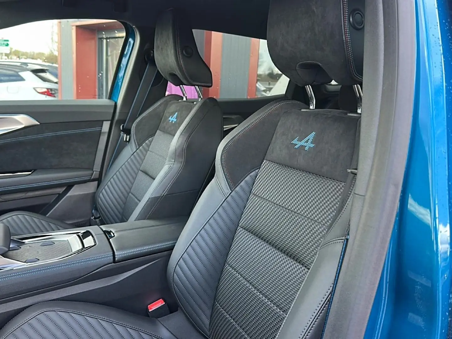 Vue intérieure côté droit des sièges avant en cuir et alcantara avec logo Alpine sur Renault Austral bleu outremer 2026.