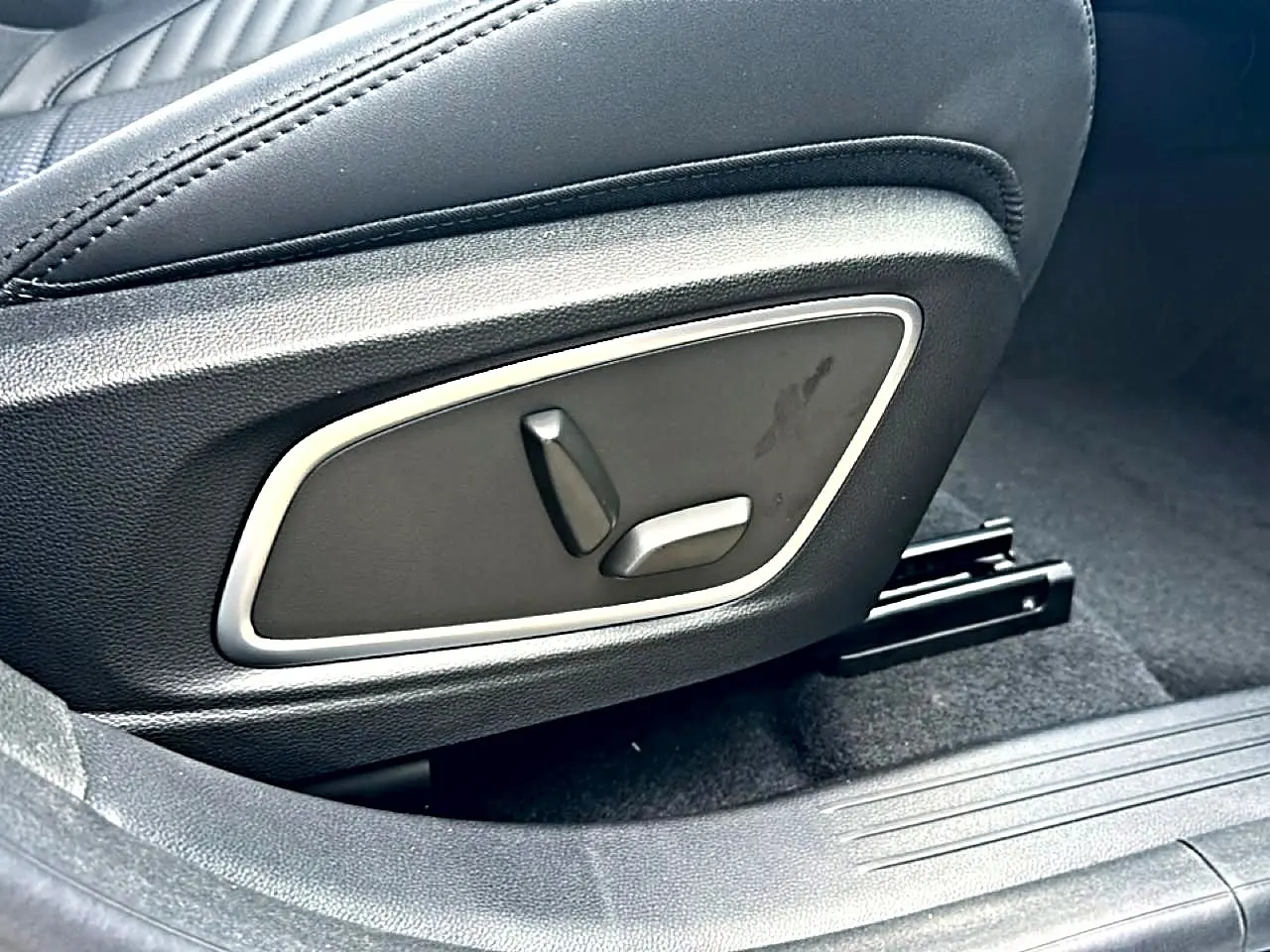 Gros plan sur les commandes électriques du siège avant noir du Renault Austral 1.2 e-tech hybride.