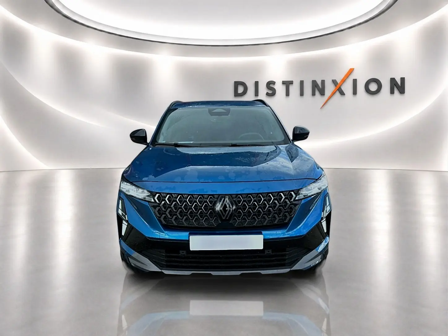 Vue avant d'un Renault Austral bleu outremer avec calandre noire et logo Renault, dans un showroom lumineux.