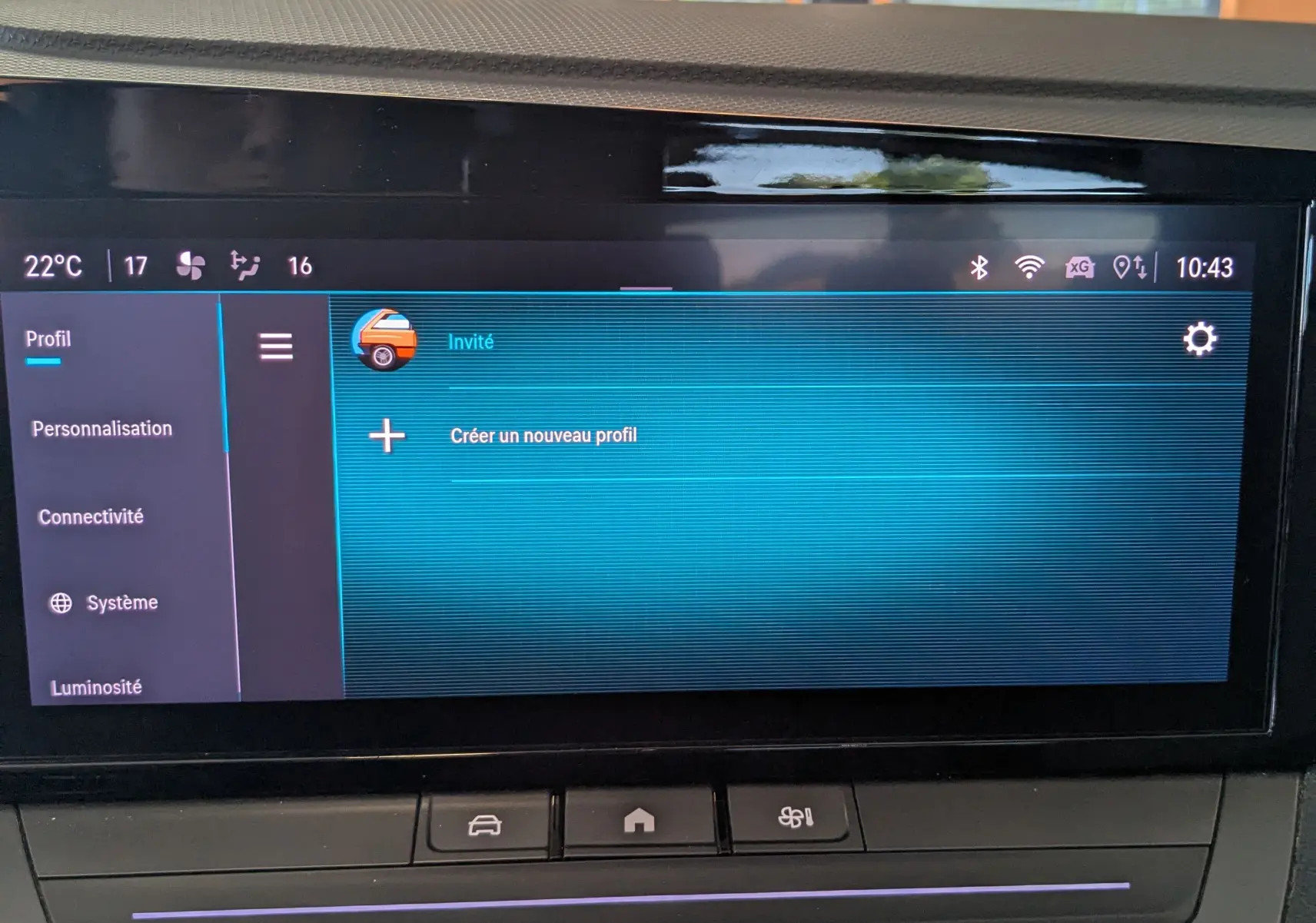 Vue rapprochée de l'écran tactile central et des commandes de climatisation d'une Opel Astra bleu 2022 en intérieur.