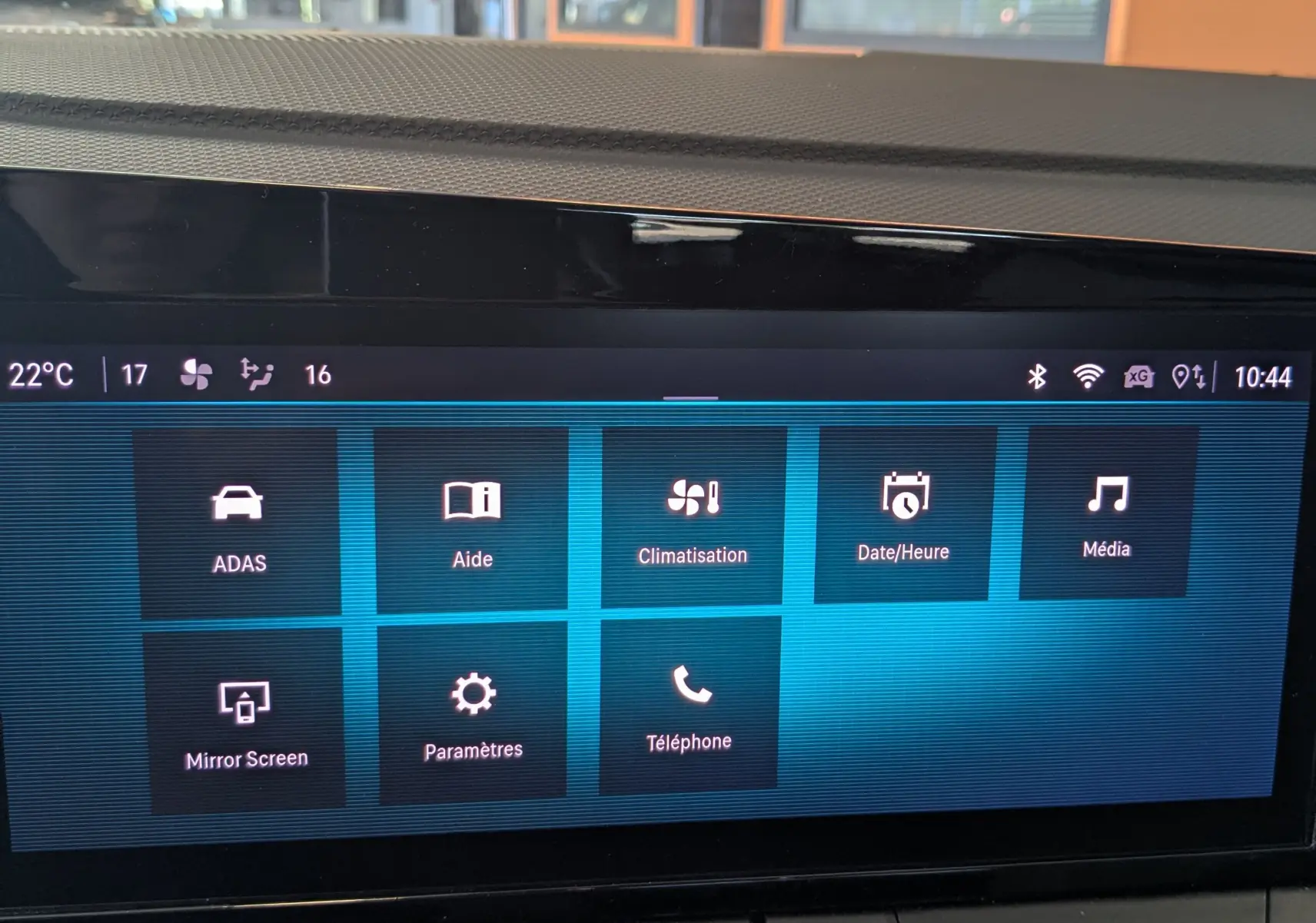 Écran tactile central de l’Opel Astra 2022 bleu, affichant les menus de climatisation, médias et téléphone.