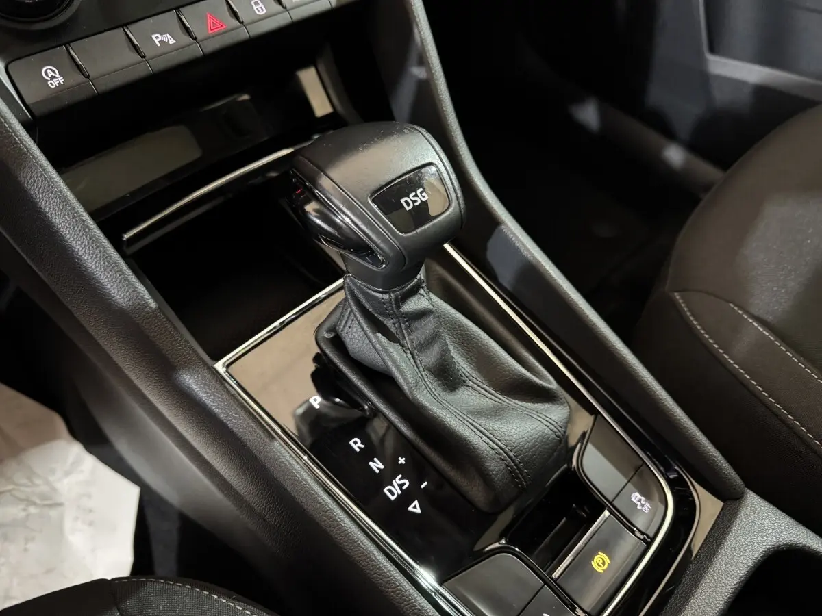 Le levier de vitesses DSG noir en gros plan sur la console centrale intérieure d'un Skoda Karoq blanc.