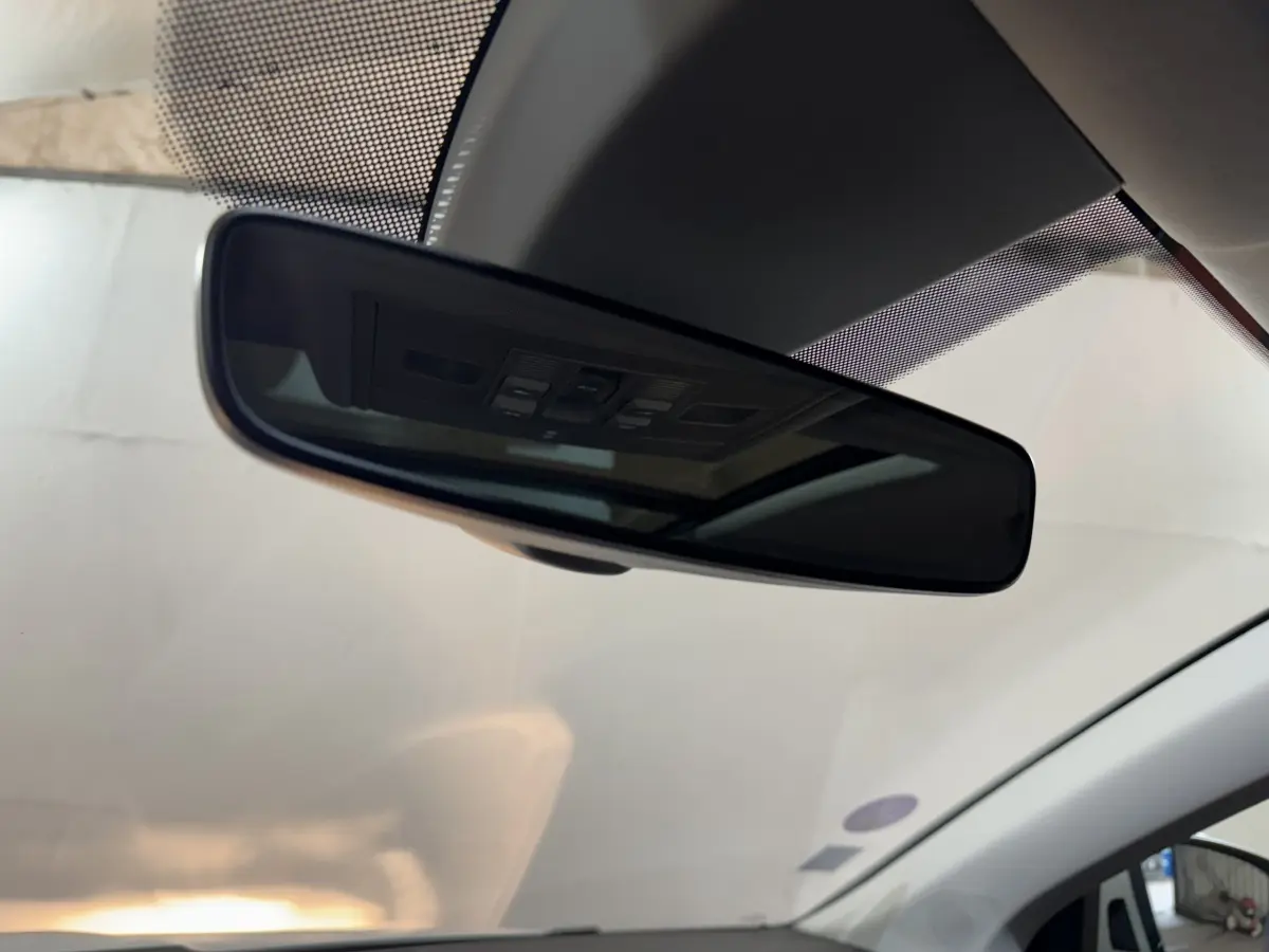 Rétroviseur intérieur noir avec commandes intégrées, vue depuis l’habitacle du Skoda Karoq blanc 2021.