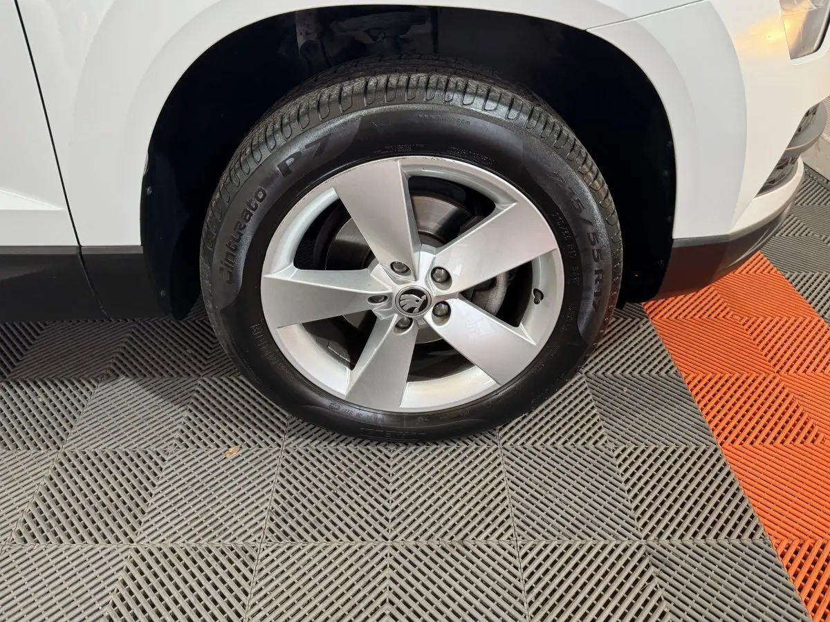 Gros plan sur la roue avant gauche blanche d'un Skoda Karoq 1.5 TSI 2021 avec jante alliage cinq branches.