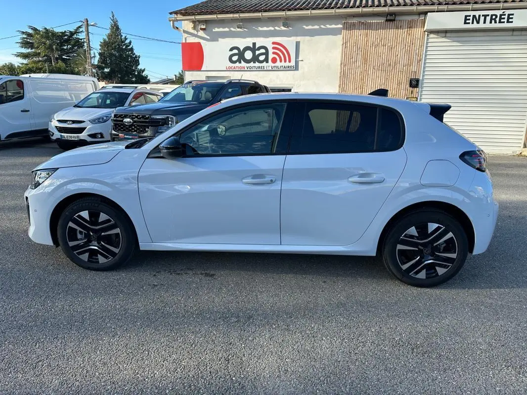 Vue de profil côté gauche d'une Peugeot 208 Hybrid 110 blanche avec jantes alliage noires et toit noir.