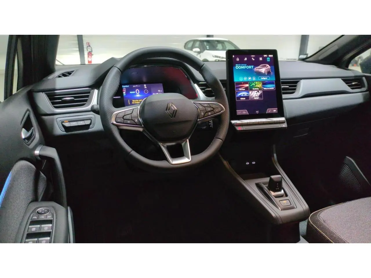 Vue intérieure du tableau de bord du Renault Captur 2026, avec volant multifonction, écran tactile vertical et console centrale flottante.