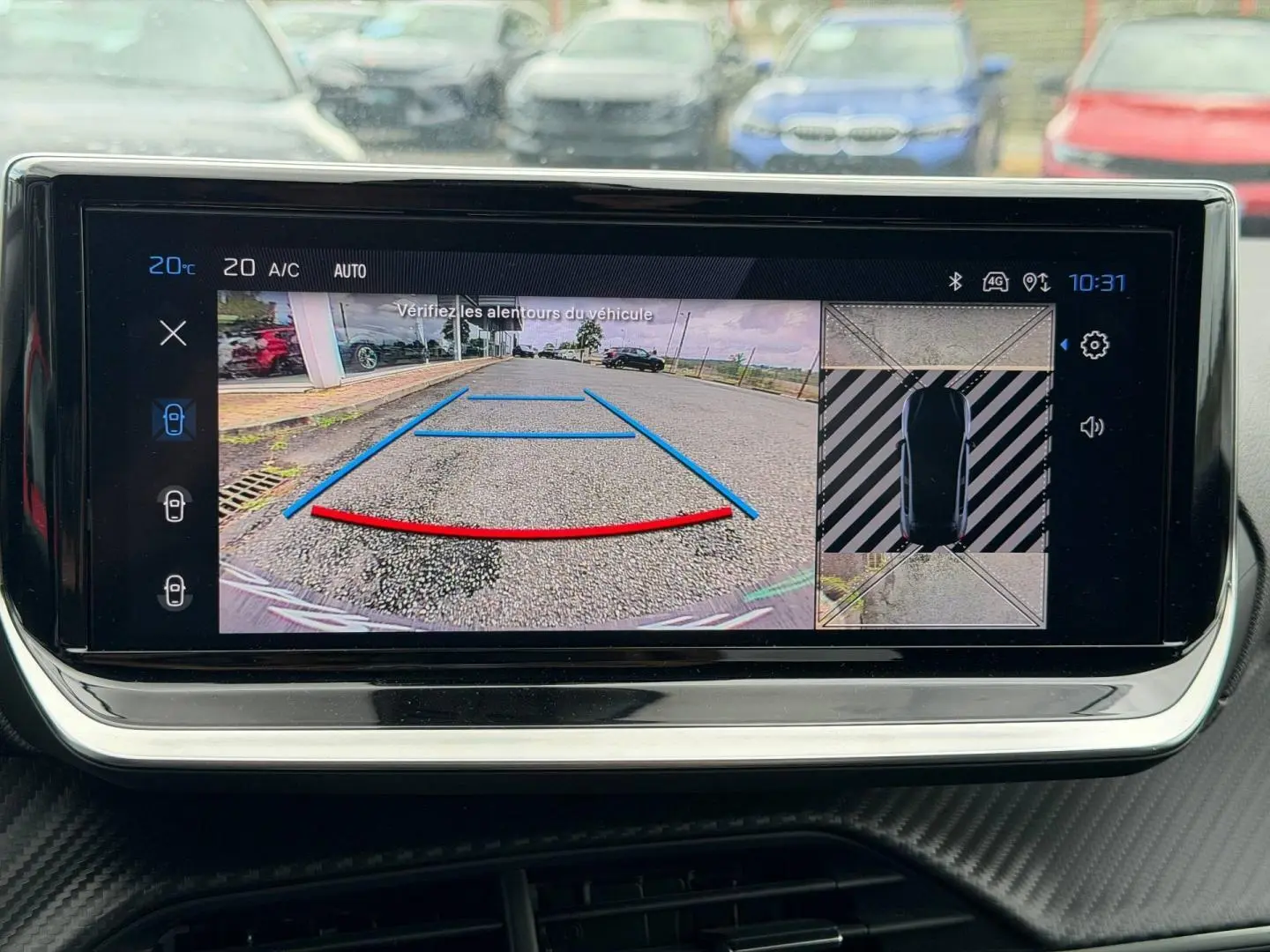 Écran tactile intérieur de Peugeot 208 noir Perla Nera montrant la caméra de recul et l'aide au stationnement.