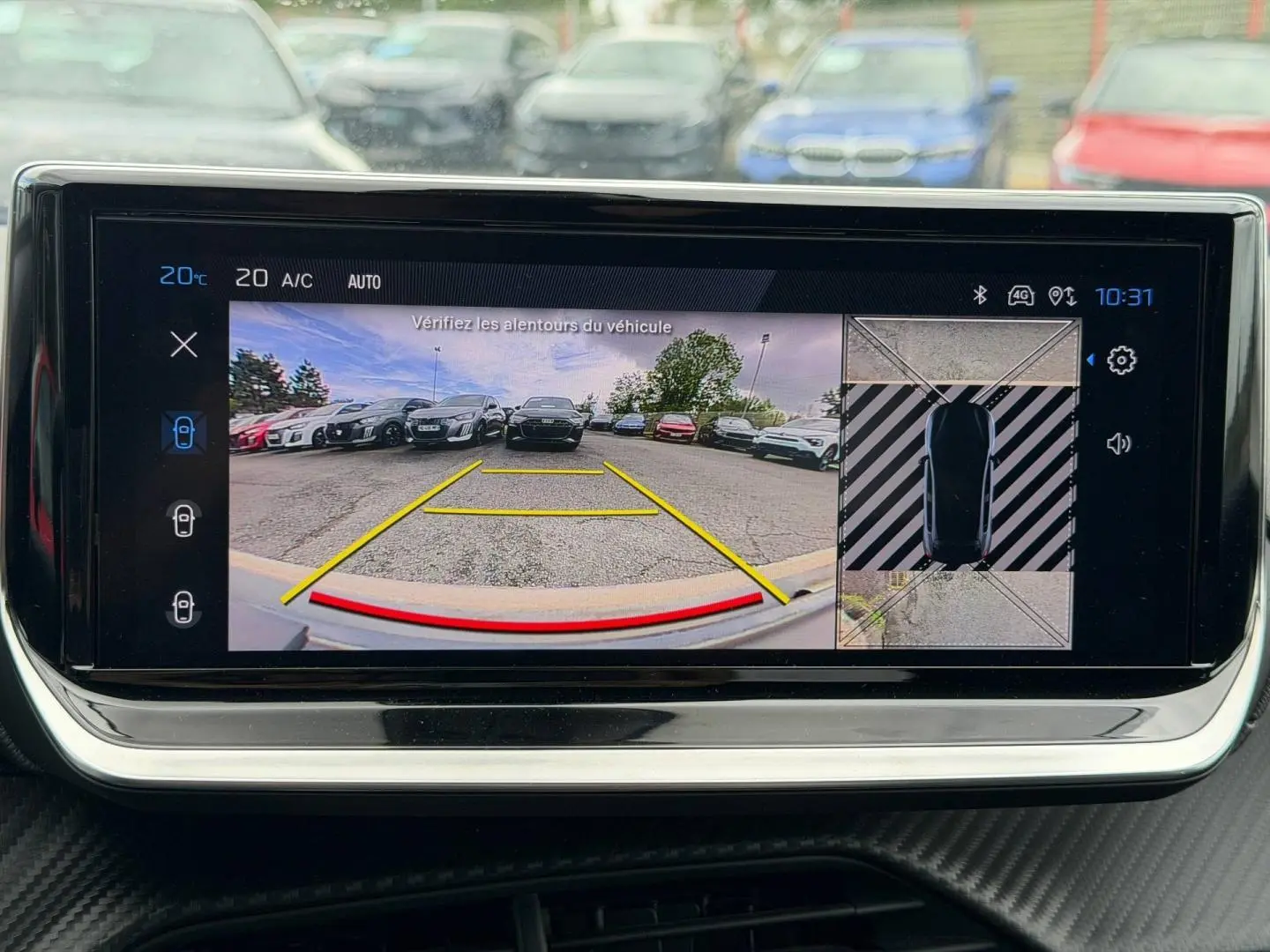 Écran tactile intérieur montrant la caméra de recul et l’aide au stationnement de la Peugeot 208 noire.