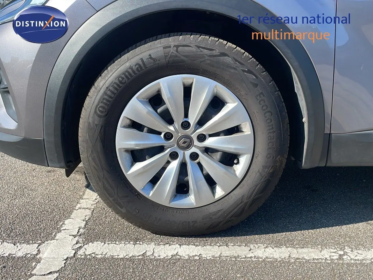 Gros plan sur la roue avant gauche d'un Renault Captur gris Cassiopée Métal avec jante alliage et pneu Continental.