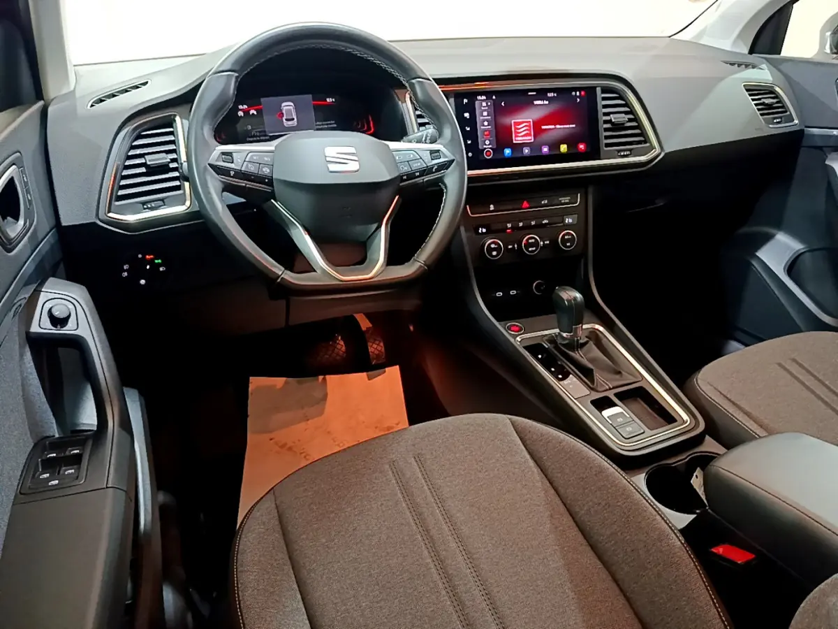 Intérieur du SEAT Ateca 2022 vu de face, tableau de bord moderne avec écran tactile et volant multifonction noir.