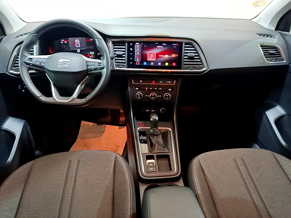 Vue intérieure avant du tableau de bord et console centrale du SEAT Ateca noir avec écran tactile et volant multifonctions.