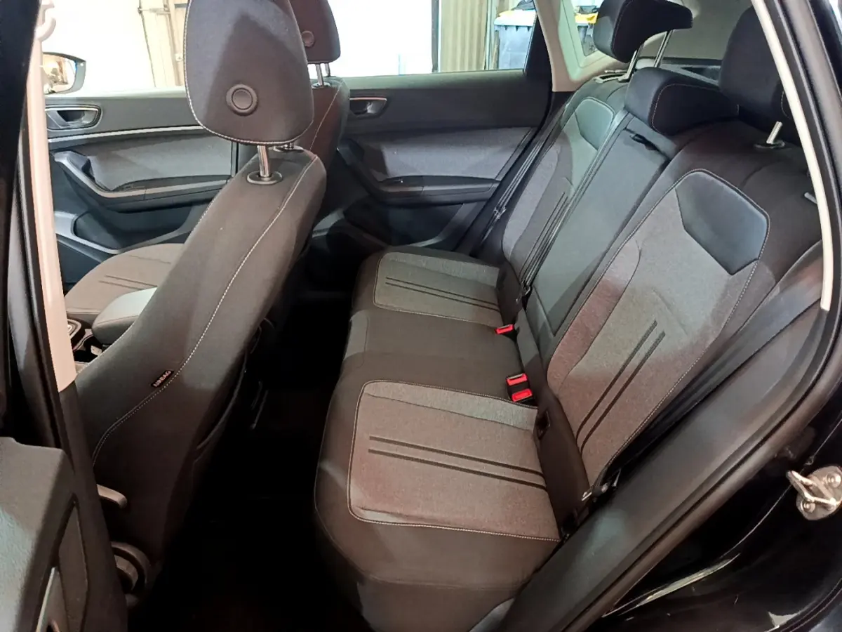 Vue intérieure côté droit sur la banquette arrière grise et noire du SEAT Ateca noir 2022 avec portes ouvertes.