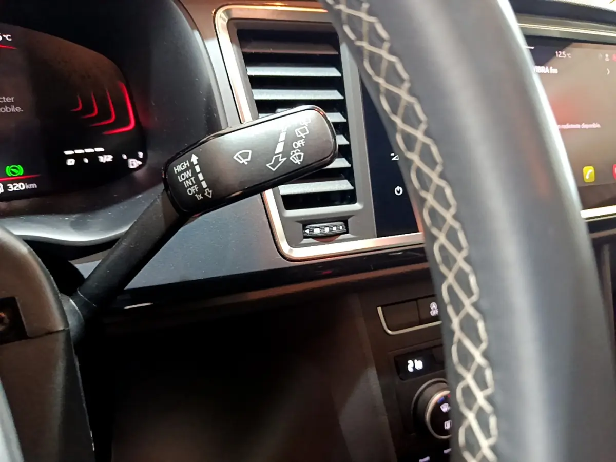 Gros plan sur la manette d’essuie-glace à gauche du volant cuir du tableau de bord noir du SEAT Ateca 2022.