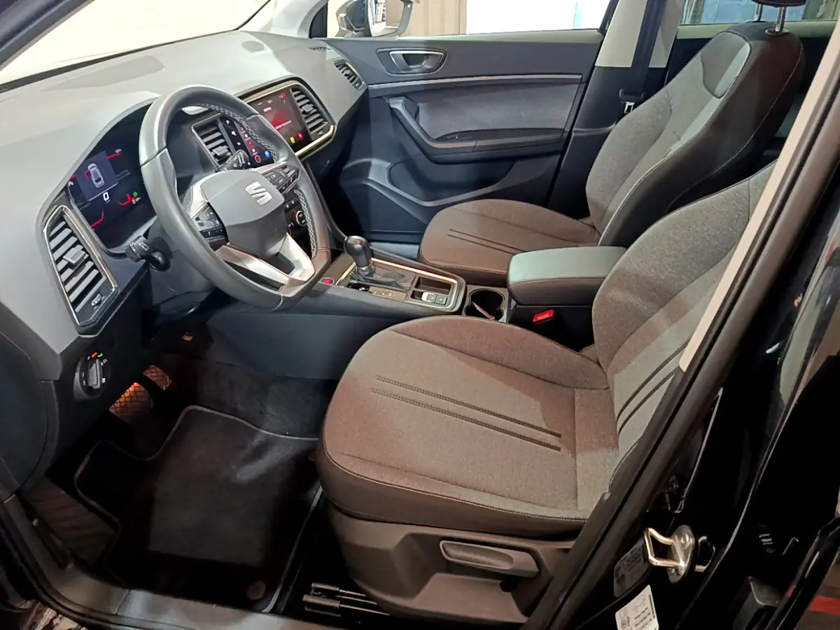 Intérieur avant droit du SEAT Ateca noir 2022, montrant sièges tissu gris, volant multifonction et écran tactile central.