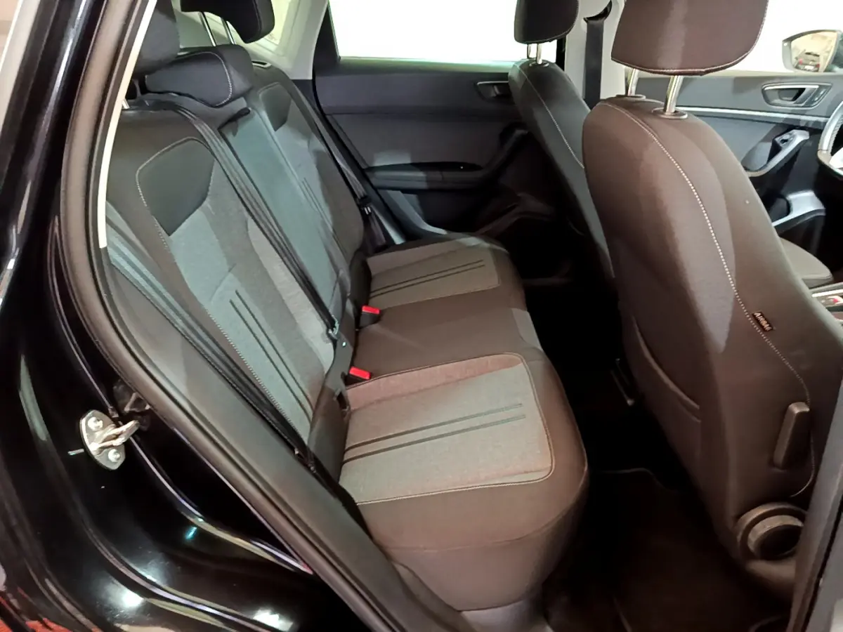 Vue intérieure côté gauche sur la banquette arrière grise et noire du SEAT Ateca noir 2022 avec détails des sièges et portière ouverte.