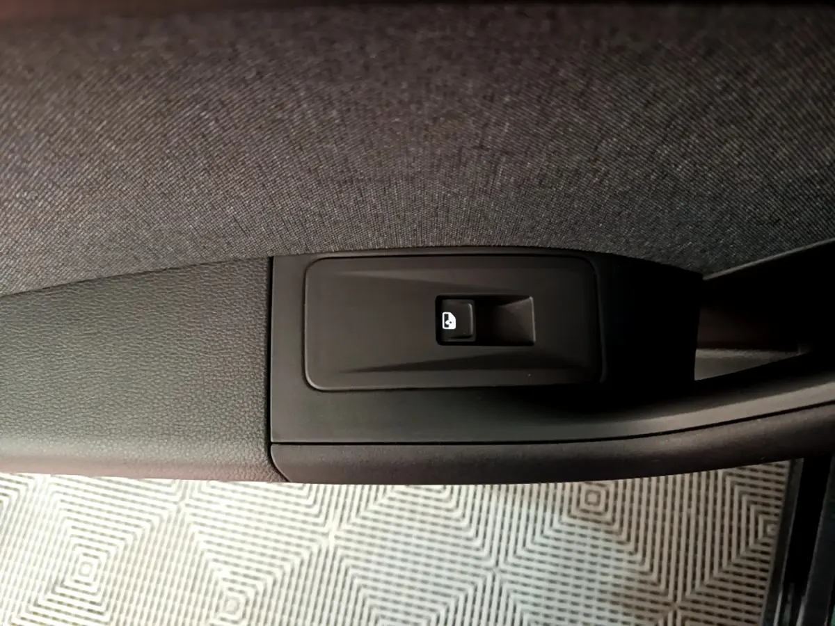 Bouton de verrouillage des portes noir sur la garniture intérieure de la portière d'un SEAT Ateca noir, vue rapprochée.