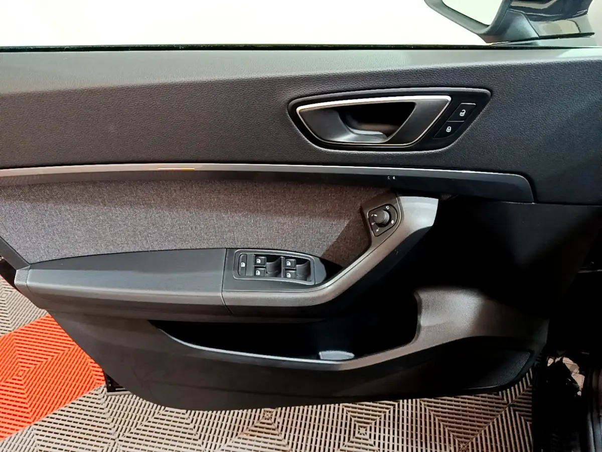 Gros plan sur la porte côté conducteur du SEAT Ateca noir, montrant les commandes de vitres et de rétroviseurs.