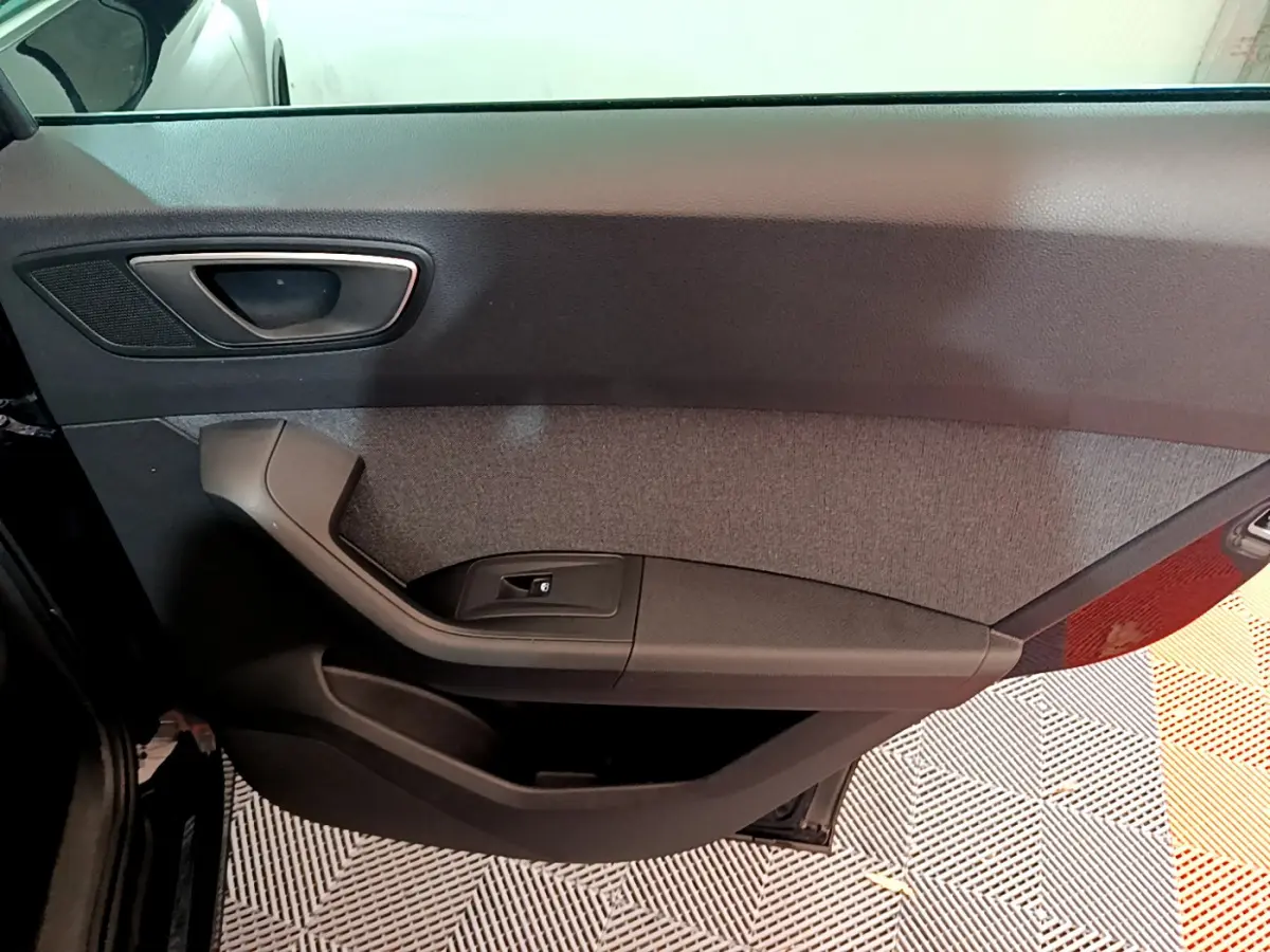 Intérieur montrant la porte côté gauche du SEAT Ateca noir avec poignée et commande de vitre électrique.