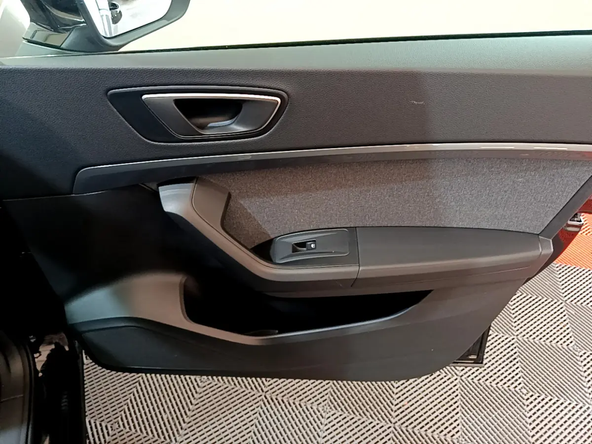 Intérieur côté gauche de la porte avant d'une SEAT Ateca noire, avec garniture tissu et poignée argentée.