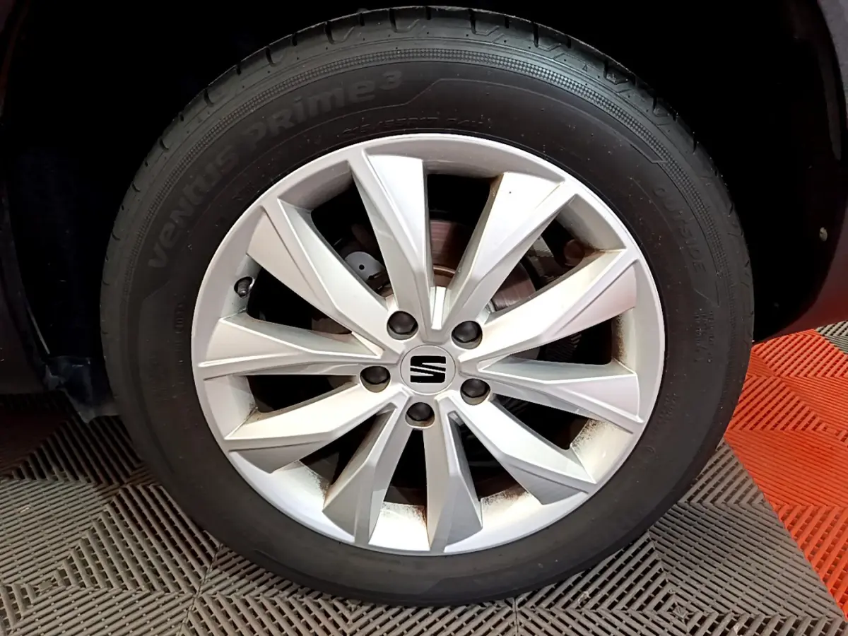 Gros plan sur la roue avant droite avec jante argentée du SEAT Ateca noir 2022.