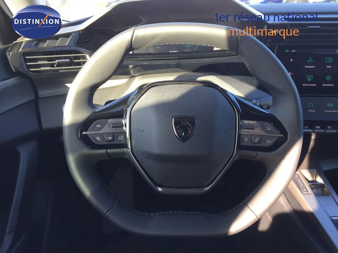 Vue rapprochée du volant cuir noir de la Peugeot 308 1.2 Hybrid 2025 avec commandes intégrées et tableau de bord digital.