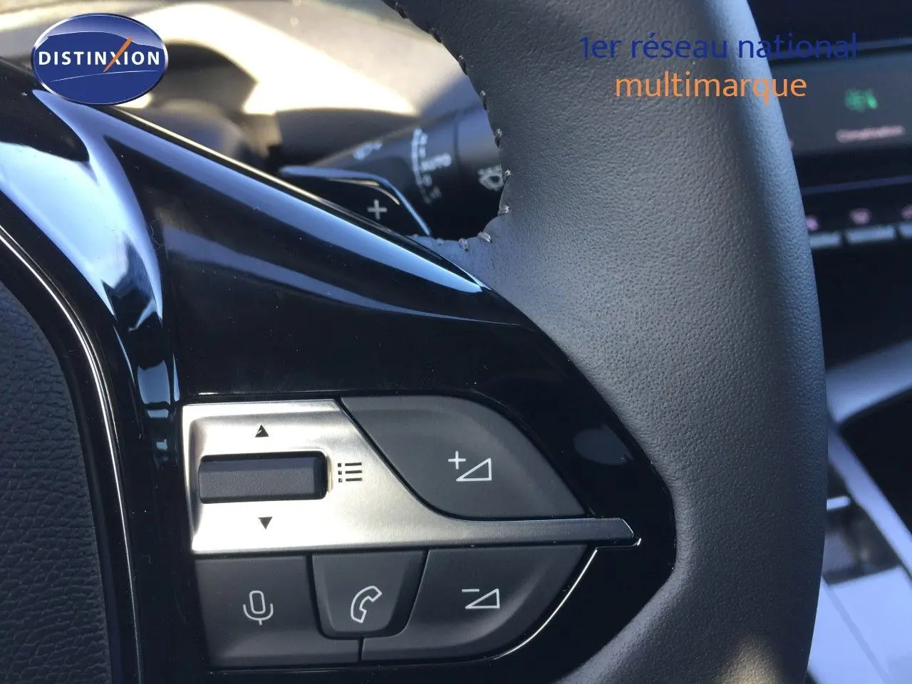 Détail du volant avec commandes intégrées sur Peugeot 308 gris Artense, intérieur moderne et finition soignée.