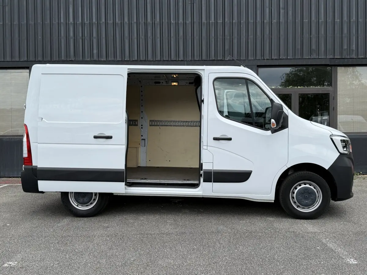 Vue latérale droite du Renault Master blanc 2024 avec porte coulissante ouverte révélant l'espace de chargement vide.