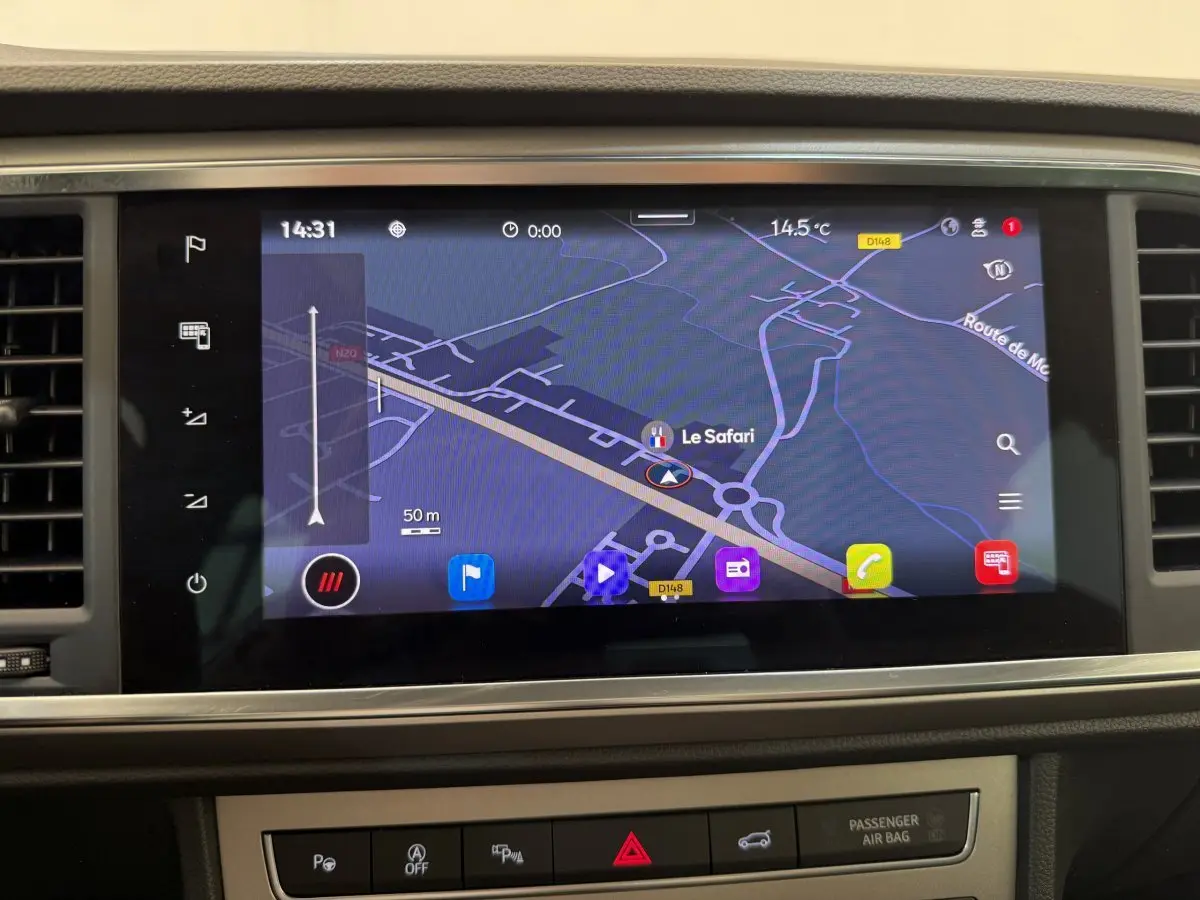 Écran tactile central du tableau de bord du SEAT Ateca gris clair, affichant la navigation GPS en plein jour.